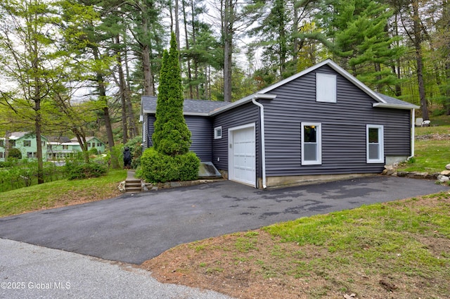 view of side of property with driveway and an attached garage