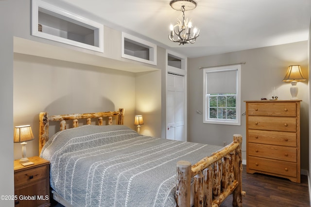 bedroom with dark wood-style flooring, a chandelier, a closet, and baseboards