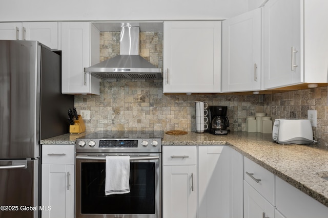 kitchen featuring appliances with stainless steel finishes, wall chimney range hood, white cabinetry, and backsplash