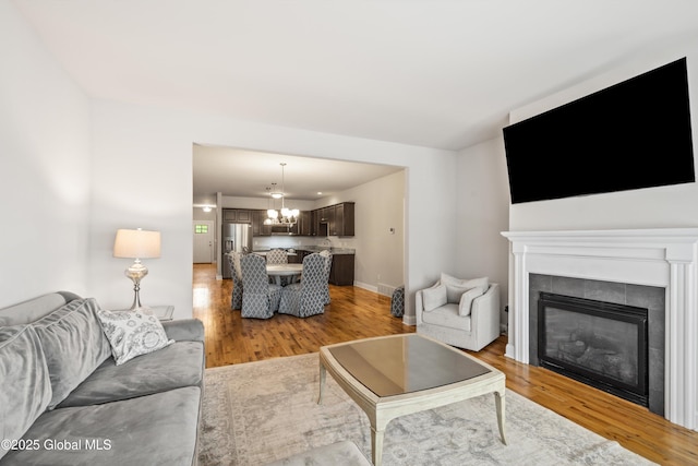 19 Pasture Pl, Ballston, NY 12019 - living room with a chandelier, light wood-type flooring, a tile fireplace, and baseboards