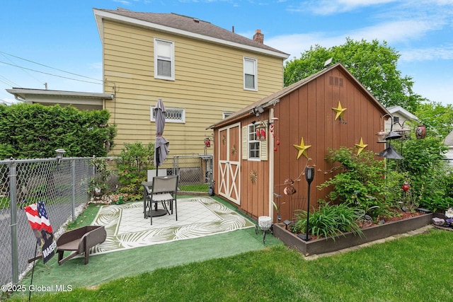 1841 Lenox Rd, Schenectady, NY 12308 - back of house with a storage unit, a chimney, an outbuilding, and a patio area