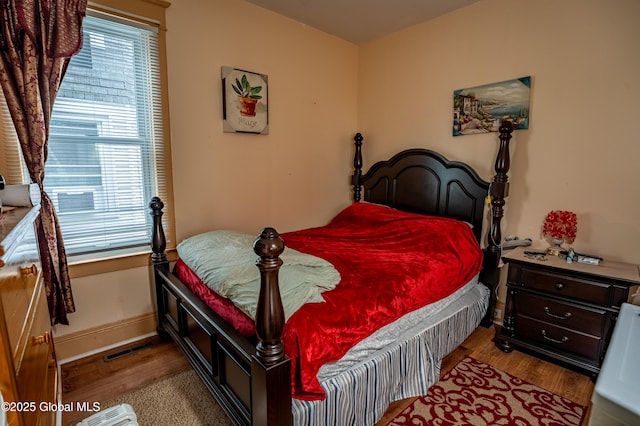 bedroom with wood finished floors and baseboards