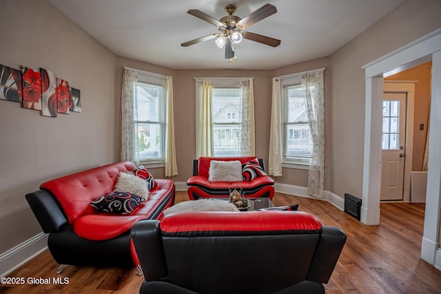 living area with plenty of natural light, wood finished floors, and baseboards