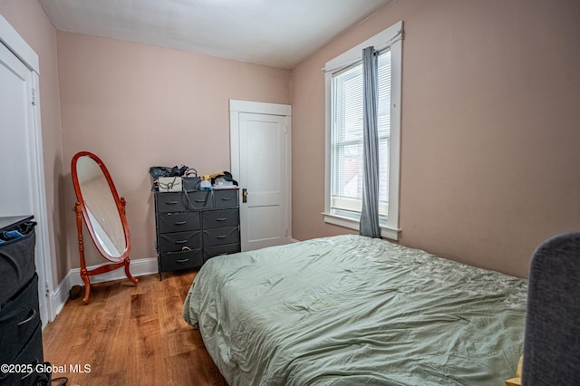 bedroom with wood finished floors and baseboards