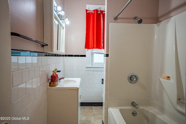 bathroom with shower / bath combination, tile walls, vanity, and wainscoting