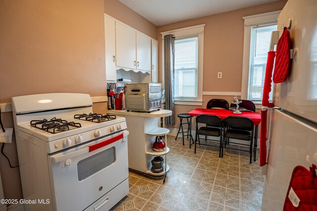 kitchen featuring white appliances and white cabinets