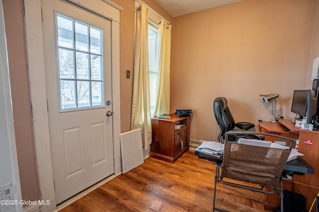 office space with wood finished floors and radiator heating unit