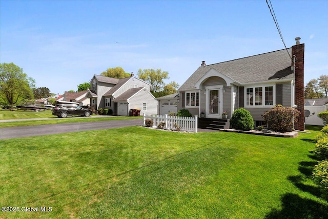 view of front of home with a chimney, asphalt driveway, and a garage