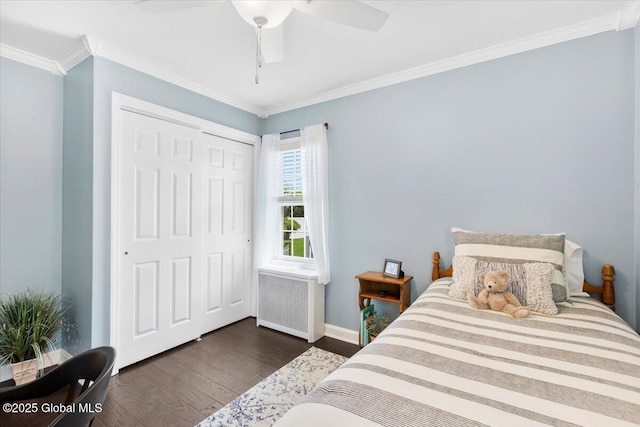 bedroom with radiator, dark wood-type flooring, ornamental molding, a closet, and baseboards