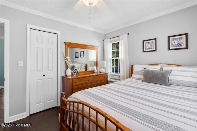 bedroom featuring a closet, ornamental molding, dark wood-style floors, ceiling fan, and baseboards