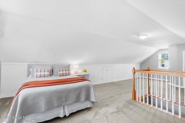 carpeted bedroom with lofted ceiling and baseboards