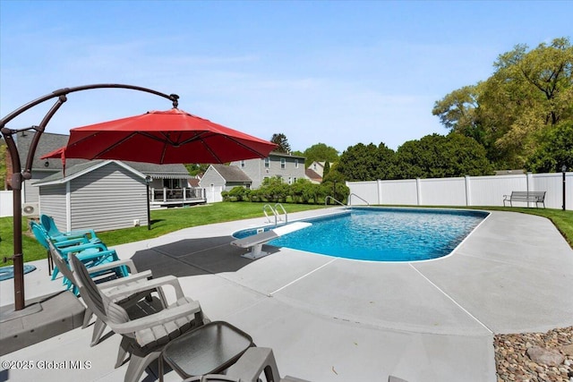 view of pool with a patio and a diving board