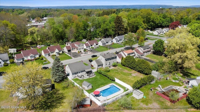 aerial view of residential area with a pool area and a heavily wooded area