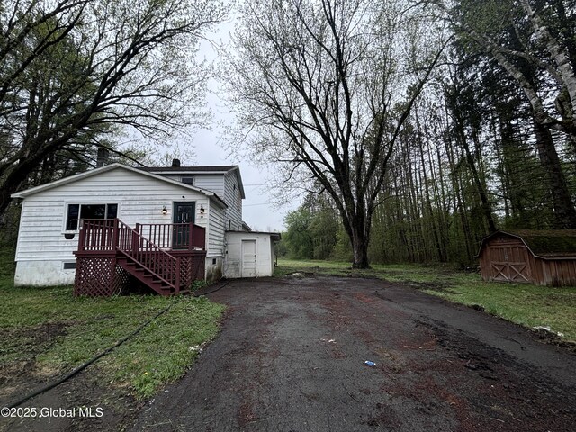 162 State Highway 67, Ephratah, NY 13339 - view of property exterior featuring an outbuilding, asphalt driveway, a shed, and a wooden deck