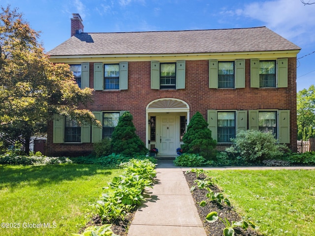 1435 Lowell Rd, Schenectady, NY 12308 - view of front of property with brick siding, a front yard, a chimney, and roof with shingles
