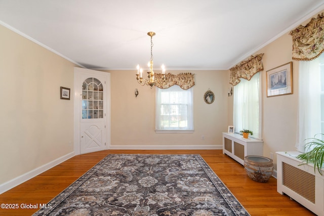 1435 Lowell Rd, Schenectady, NY 12308 - dining space with a chandelier, wood finished floors, ornamental molding, radiator heating unit, and baseboards