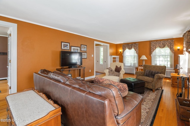 1435 Lowell Rd, Schenectady, NY 12308 - living room featuring radiator, wood finished floors, crown molding, and baseboards