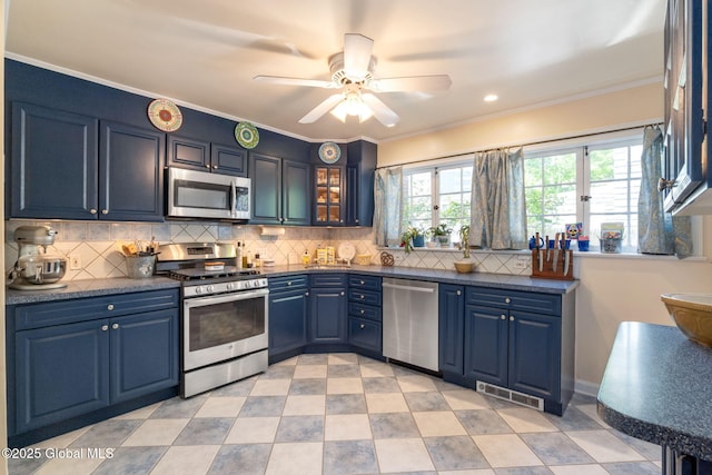 1435 Lowell Rd, Schenectady, NY 12308 - kitchen with stainless steel appliances, blue cabinetry, ceiling fan, tasteful backsplash, and glass insert cabinets
