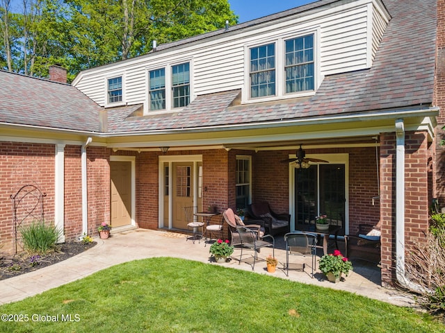 1435 Lowell Rd, Schenectady, NY 12308 - back of property featuring a patio area, a ceiling fan, a lawn, and brick siding