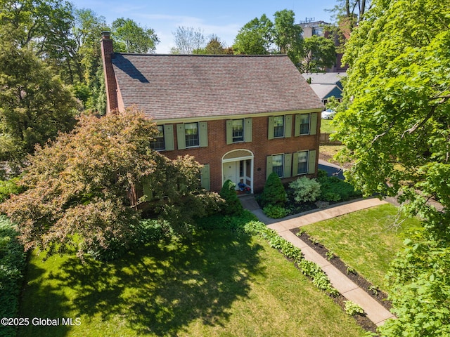 1435 Lowell Rd, Schenectady, NY 12308 - colonial home featuring a chimney, a front lawn, brick siding, and a shingled roof
