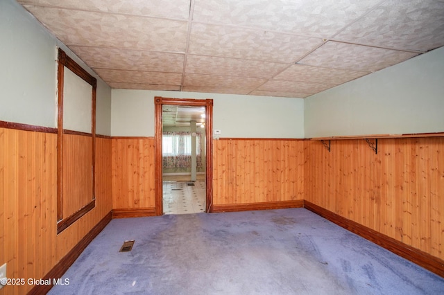127 John St, Hudson Falls, NY 12839 - carpeted empty room featuring a wainscoted wall, a drop ceiling, wood walls, and baseboards