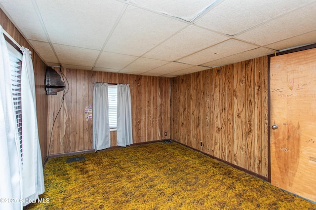 127 John St, Hudson Falls, NY 12839 - unfurnished room featuring a drop ceiling, wood walls, and dark carpet