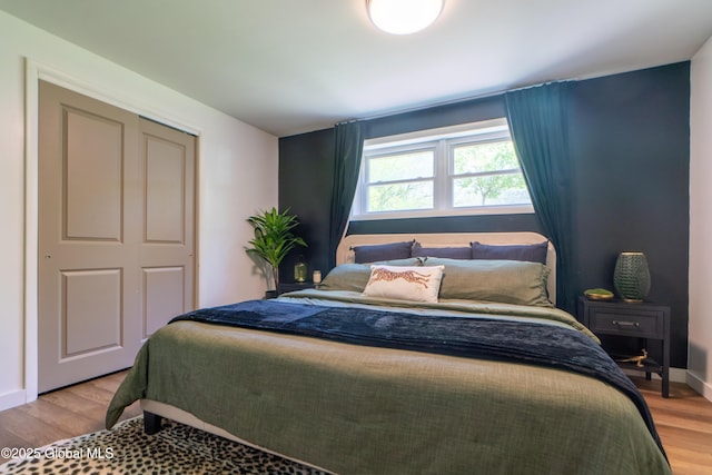 bedroom featuring light wood-style floors, a closet, and baseboards