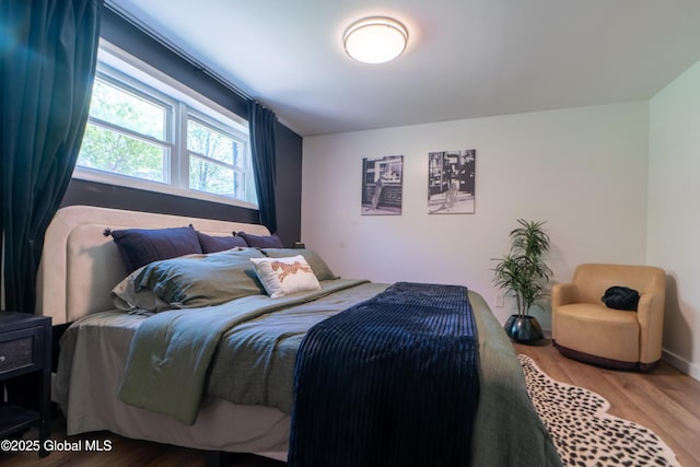 bedroom featuring wood finished floors and baseboards