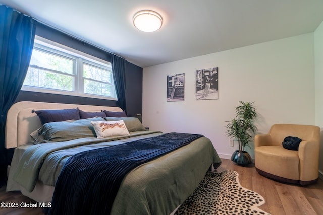 bedroom with wood finished floors and baseboards
