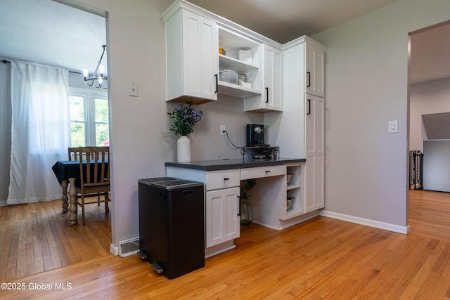office with light wood finished floors, a chandelier, and baseboards