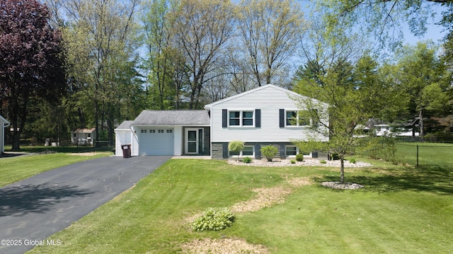 tri-level home featuring an attached garage and asphalt driveway