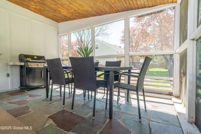 sunroom with wood ceiling, a decorative wall, and lofted ceiling