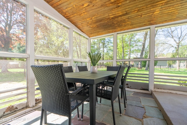 sunroom / solarium featuring vaulted ceiling and outdoor dining space