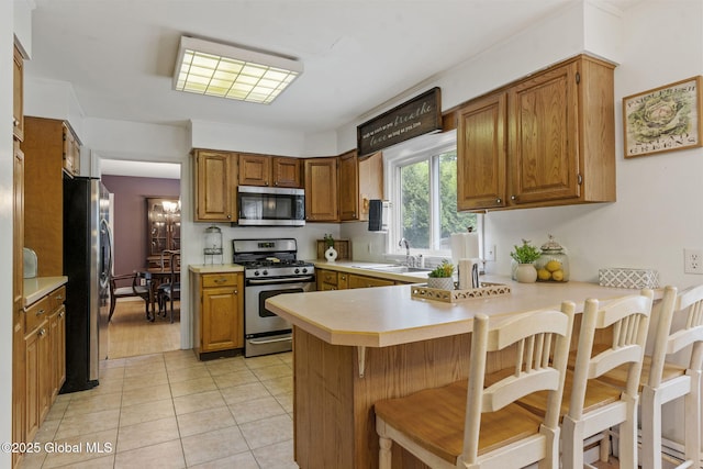 15 Oak Tree Ln, Colonie, NY 12309 - kitchen with appliances with stainless steel finishes, a sink, a peninsula, light countertops, and brown cabinets