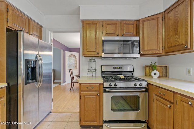 15 Oak Tree Ln, Colonie, NY 12309 - kitchen with appliances with stainless steel finishes, light countertops, brown cabinets, and light tile patterned floors