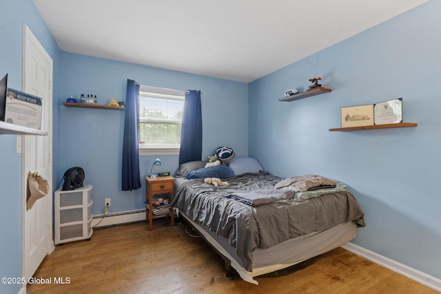 15 Oak Tree Ln, Colonie, NY 12309 - bedroom featuring baseboard heating, wood finished floors, and baseboards