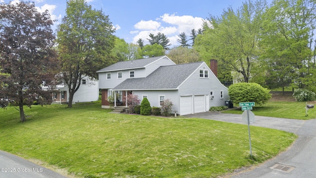 15 Oak Tree Ln, Colonie, NY 12309 - traditional-style house featuring asphalt driveway, a chimney, a front yard, a shingled roof, and a garage
