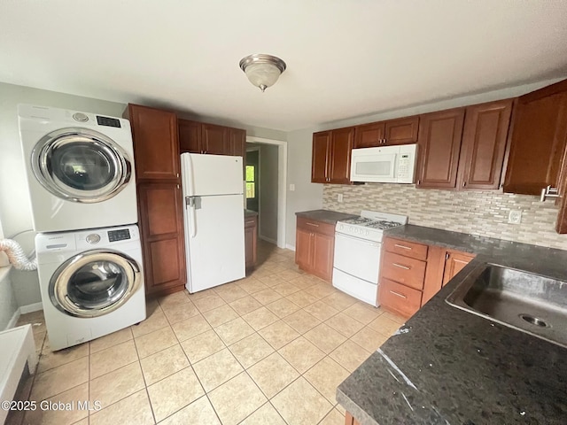 31-33 Malta Ave, Ballston Spa, NY 12020 - kitchen with white appliances, stacked washer / drying machine, dark countertops, light tile patterned floors, and decorative backsplash