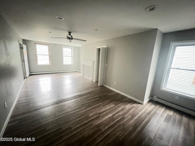 31-33 Malta Ave, Ballston Spa, NY 12020 - unfurnished living room featuring a baseboard heating unit, dark wood finished floors, baseboards, and a ceiling fan