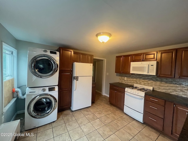 31-33 Malta Ave, Ballston Spa, NY 12020 - kitchen featuring white appliances, stacked washer / drying machine, dark countertops, light tile patterned floors, and tasteful backsplash