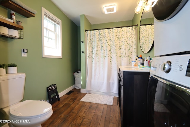 11 Filkins Ln, Voorheesville, NY 12186 - bathroom with stacked washer / drying machine, wood finished floors, toilet, vanity, and baseboards