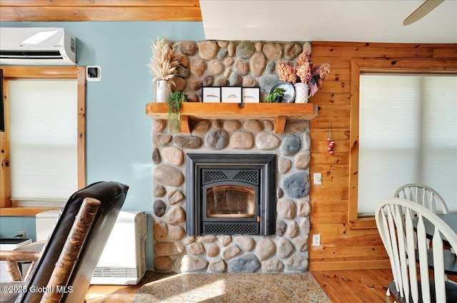 126 Lakeview Ln, Mayfield, NY 12117 - detailed view of a wall mounted AC, wood finished floors, a fireplace, and wood walls