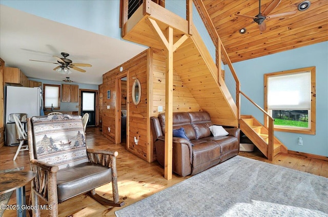 126 Lakeview Ln, Mayfield, NY 12117 - living room with ceiling fan, light wood-style flooring, stairs, and wooden walls