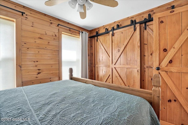 126 Lakeview Ln, Mayfield, NY 12117 - bedroom featuring wooden walls, a barn door, and ceiling fan