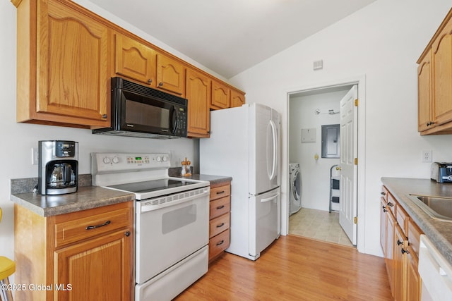 kitchen with white appliances, washing machine and clothes dryer, vaulted ceiling, dark countertops, and light wood-style flooring