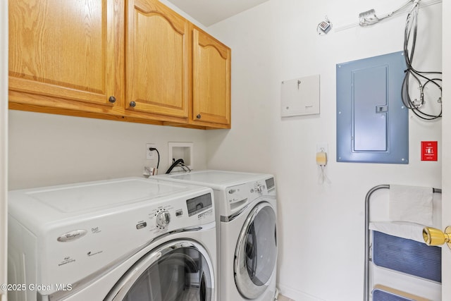 clothes washing area with electric panel, cabinet space, and washing machine and dryer