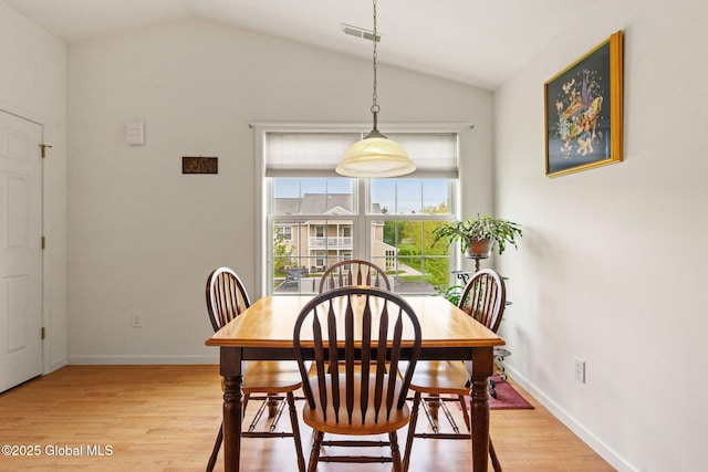 dining room with lofted ceiling, light wood-style floors, and baseboards