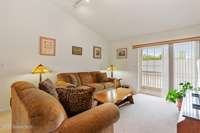 carpeted living room featuring lofted ceiling and rail lighting