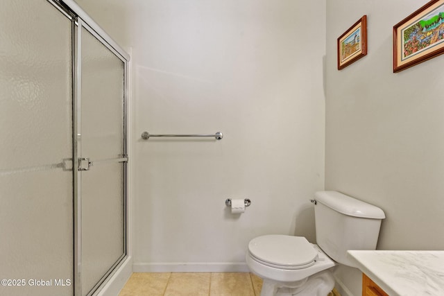 bathroom with baseboards, tile patterned flooring, a shower with shower door, and toilet