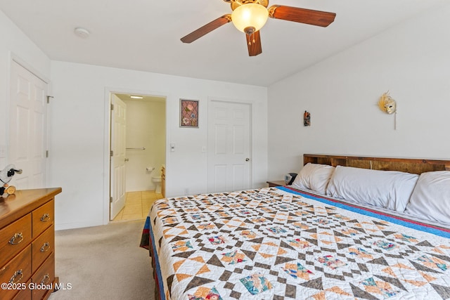 bedroom with light colored carpet, connected bathroom, and a ceiling fan